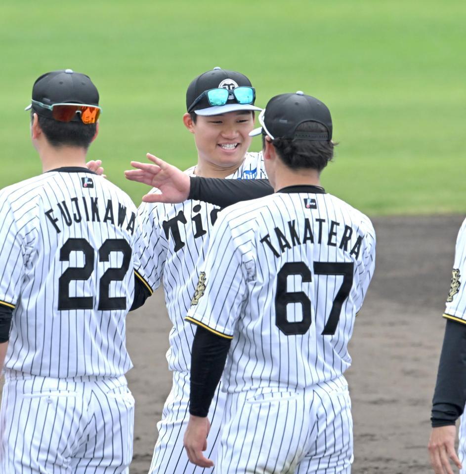 　充実のキャンプを打ち上げ、藤川監督（２２）らと笑顔でタッチを交わす森下（撮影・飯室逸平）