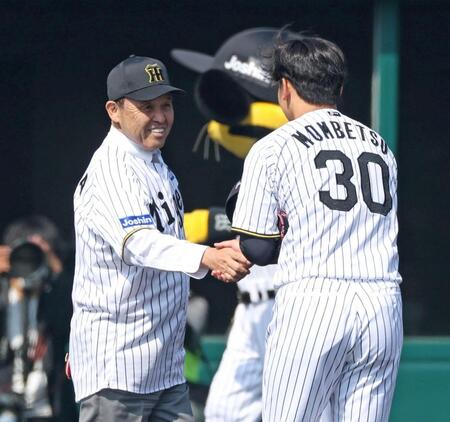　始球式を終え、門別（右）と握手を交わす岡田オーナー付顧問（撮影・中田匡峻）