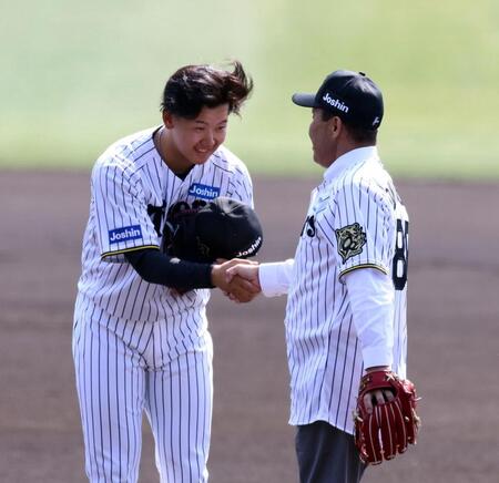 　始球式を終えた岡田彰布オーナー付顧問（右）と握手をする門別（撮影・山口登）