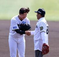 　始球式を終えた岡田彰布オーナー付顧問（右）と握手をする門別（撮影・山口登）