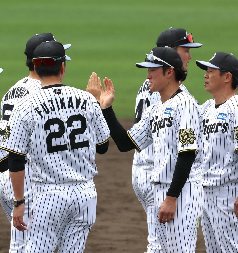 　手締め後、藤川監督とタッチを交わす高寺（右から２人目）＝撮影・北村雅宏