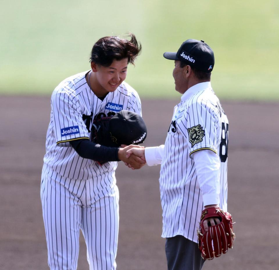 　始球式を終えた岡田彰布オーナー付顧問（右）と握手をする門別（撮影・山口登）