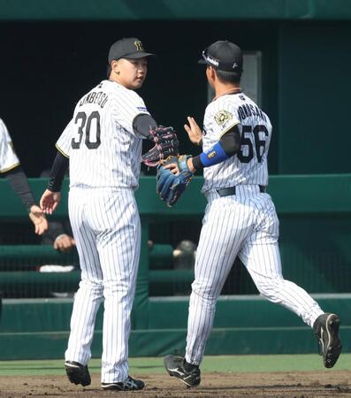 　２回を投げ終え、百崎（右）とタッチを交わす門別（撮影・中田匡峻）