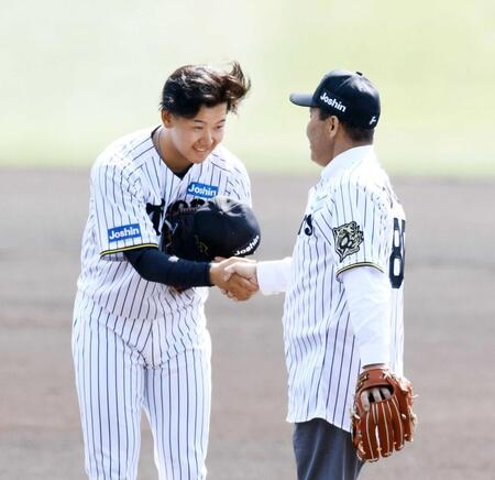 　始球式を終えた岡田オーナー付顧問（右）と握手する門別（撮影・山口登）