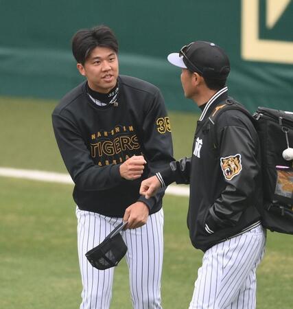 　日高ファームバッテリーコーチ（右）とグータッチする才木（撮影・西田忠信）