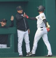 　７回、同点となる２点適時二塁打を放った佐野（右）を迎える平田２軍監督（撮影・中田匡峻）