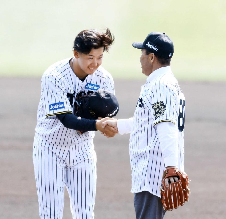 　始球式を終えた岡田オーナー付顧問（右）と握手する門別（撮影・山口登）