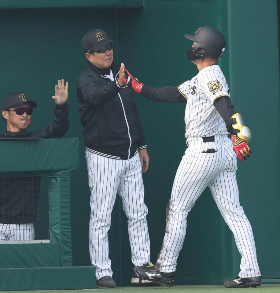 　７回、同点となる２点適時二塁打を放った佐野（右）を迎える平田２軍監督（撮影・中田匡峻）