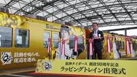 　ラッピングトレインを背にあいさつをする粟井社長（撮影・中田匡峻）