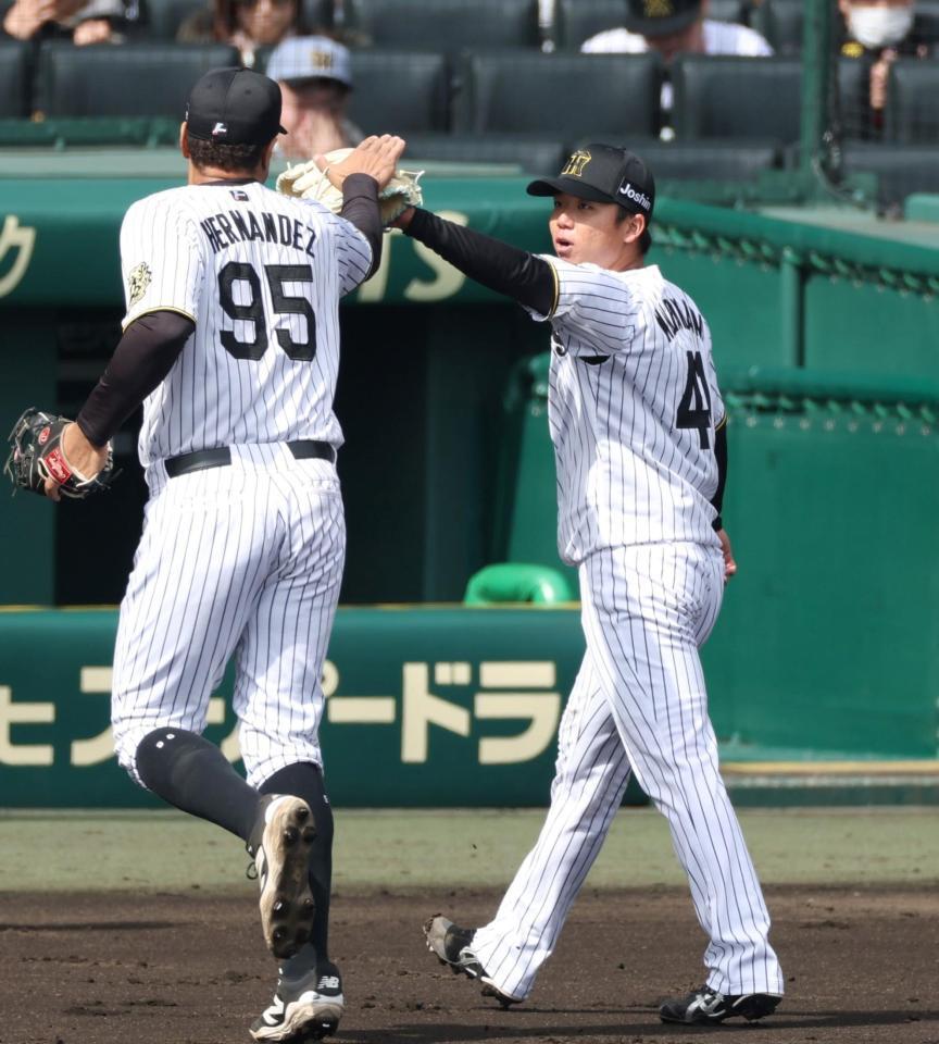 　２回を投げ終え、ヘルナンデス（左）とタッチを交わしてベンチに戻る村上（撮影・中田匡峻）