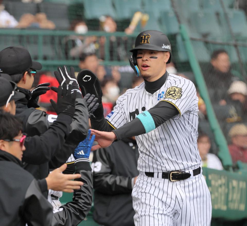 　７回、大山の適時二塁打で生還し、ナインとタッチを交わす佐藤輝（撮影・北村雅宏）