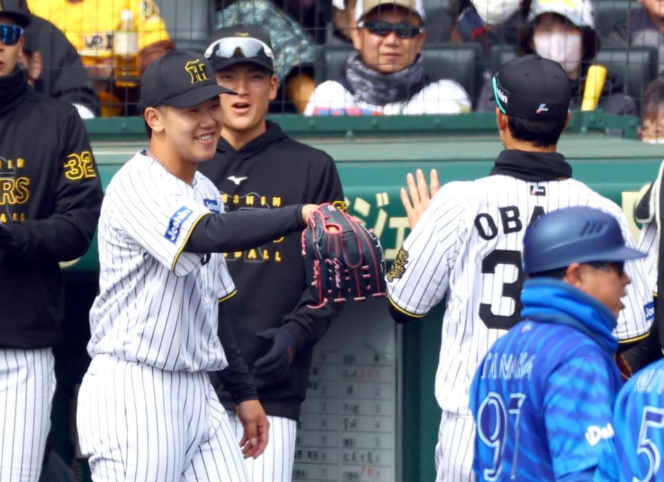 １回、好守を見せた小幡（右）を笑顔で迎える門別（左）＝撮影・山口登