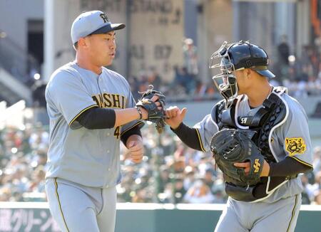 　１イニングを無失点に抑え、藤田（右）とタッチを交わす桐敷（撮影・西岡正）