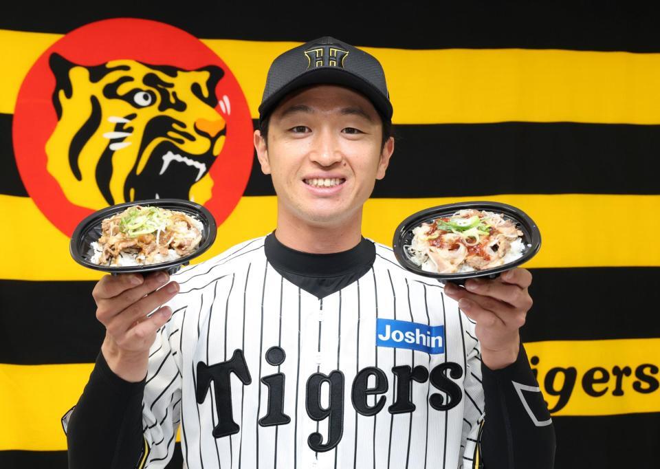 　「近本のさっぱり牛カルビ丼～淡路島産たまねぎ盛り・デミ風ソースｖｅｒ．～」を手に笑顔を見せる近本（撮影・中田匡峻）