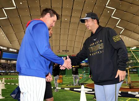 　カウンセル監督（左）と握手する藤川監督（撮影・西岡正）