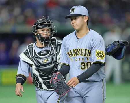 　１回を投げ終え、りりしい表情で梅野（左）とベンチに戻る門別（撮影・中田匡峻）