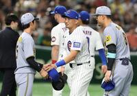 　近本（左）と握手を交わす鈴木。右は佐藤輝（撮影・中田匡峻）