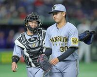 　１回を投げ終え、りりしい表情で梅野（左）とベンチに戻る門別（撮影・中田匡峻）