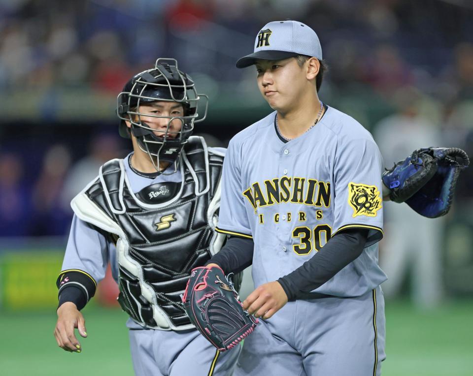 　１回を投げ終え、りりしい表情で梅野（左）とベンチに戻る門別（撮影・中田匡峻）