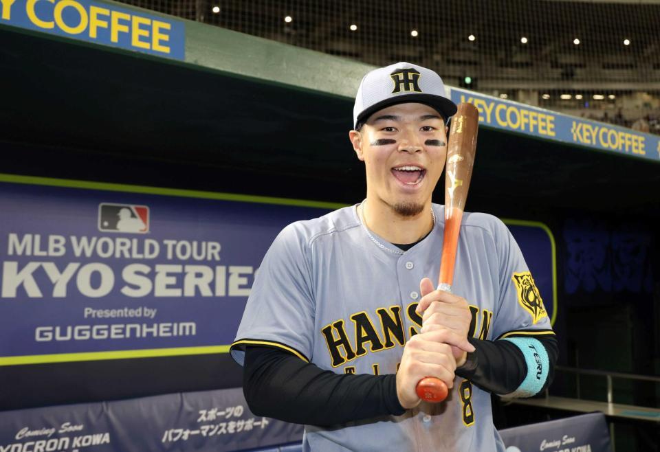 　試合後にバットを手に笑顔を見せる佐藤輝（撮影・中田匡峻）