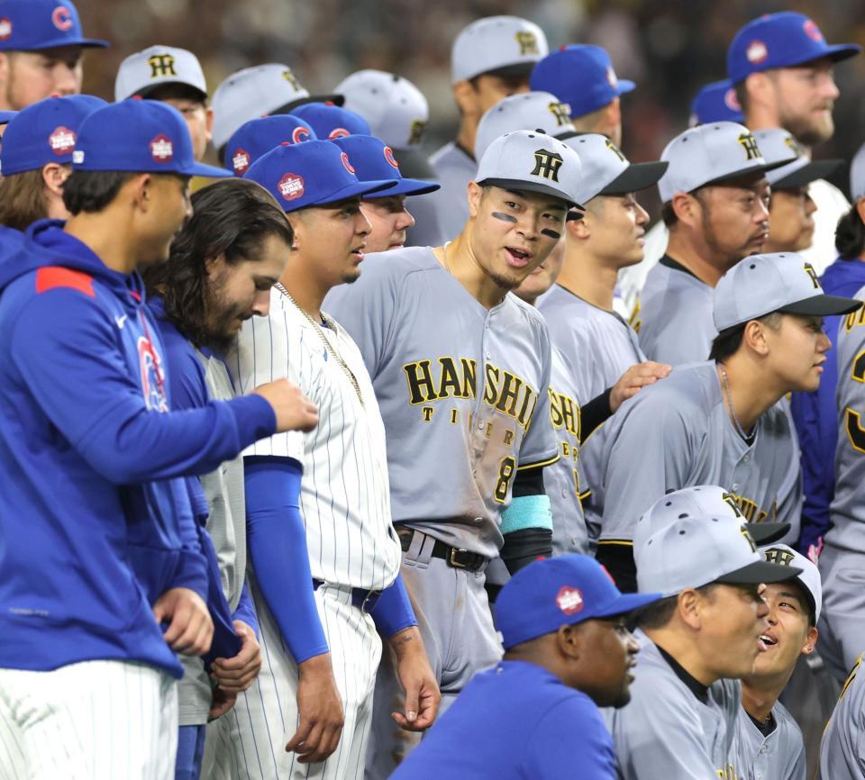 　記念撮影でカブス選手らと話す佐藤輝（中央）＝撮影・西岡正