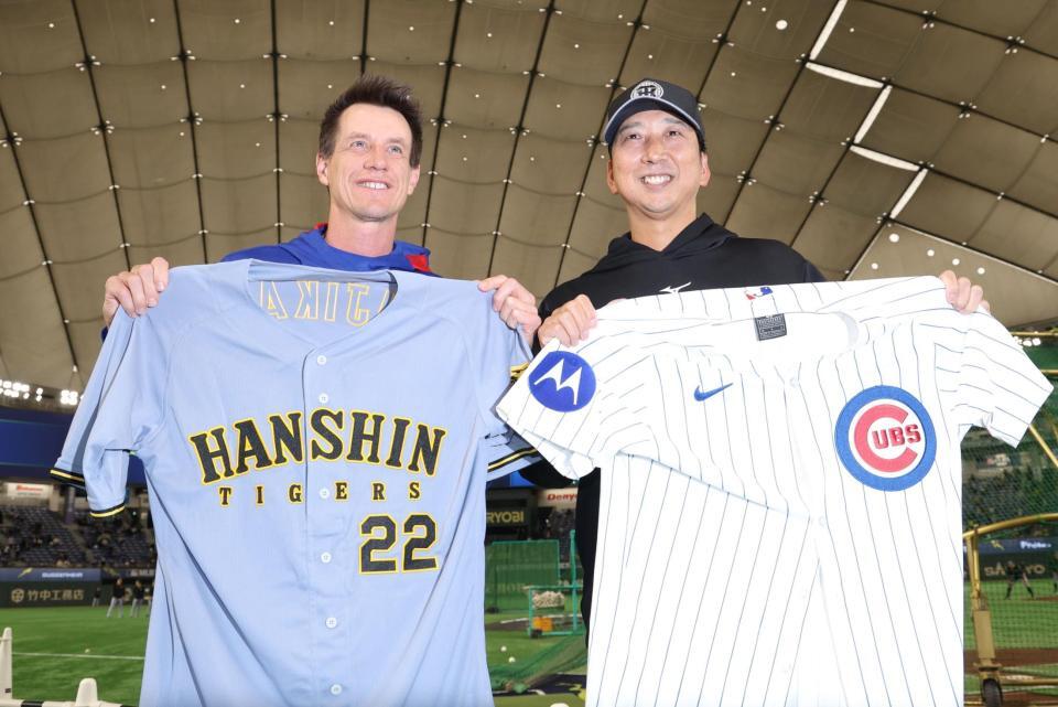 　カウンセル監督（左）とユニホーム交換する藤川監督（撮影・西岡正）