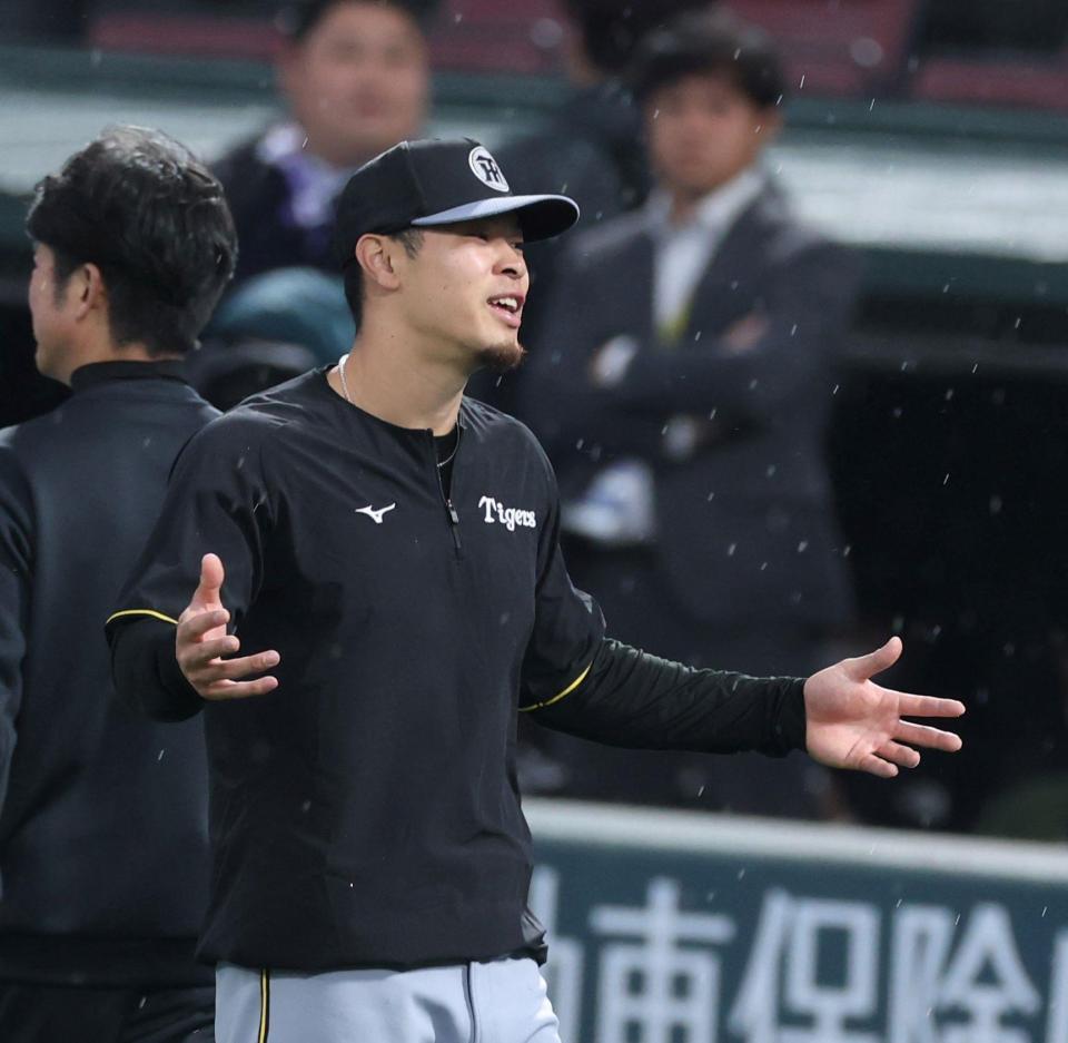 　アップ中に雨が降り出し、両手を広げる佐藤輝（撮影・中田匡峻）