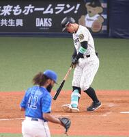 　５回、ジャクソン（手前）から空振り三振を奪われた佐藤輝（撮影・中田匡峻）