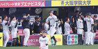 　８回、同点２ランを放ちベンチの出迎えにタッチを交わして応じる佐藤輝（中央）＝撮影・立川洋一郎