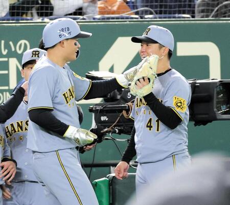 　７回、木浪の走者一掃の二塁打で生還した森下（左）とタッチを交わす村上（撮影・西岡正）