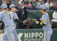 ２回、好返球でピンチを救った近本（右）とタッチする富田（撮影・西岡正）