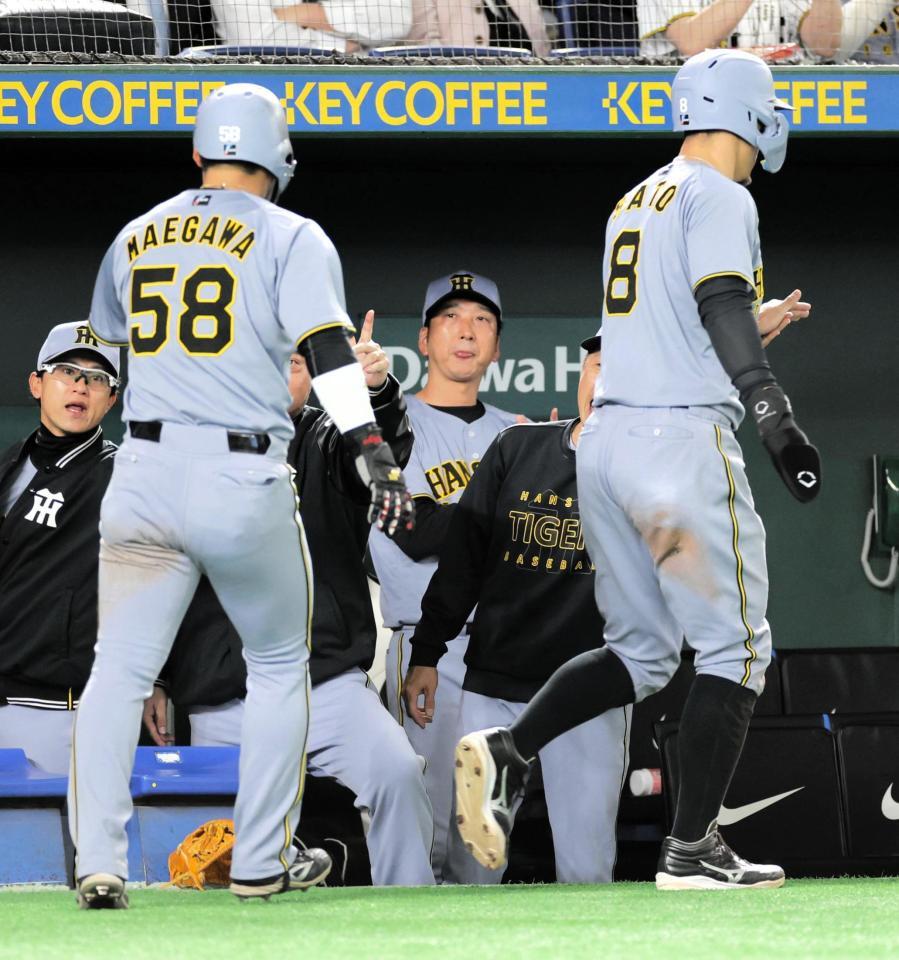 　７回、木浪の走者一掃の二塁打で生還した前川（左）と佐藤輝（右）を祝福する藤川監督（中央）＝撮影・西岡正