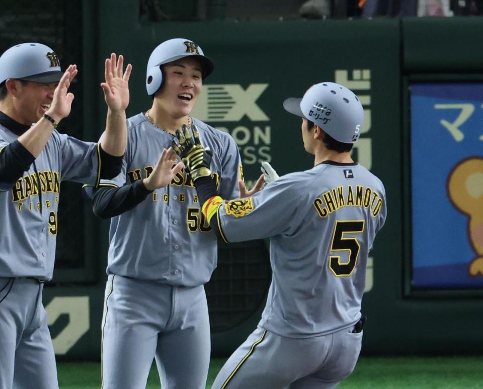 ３回、２ランを放った近本（右）を迎える富田（中央）＝撮影・金田祐二