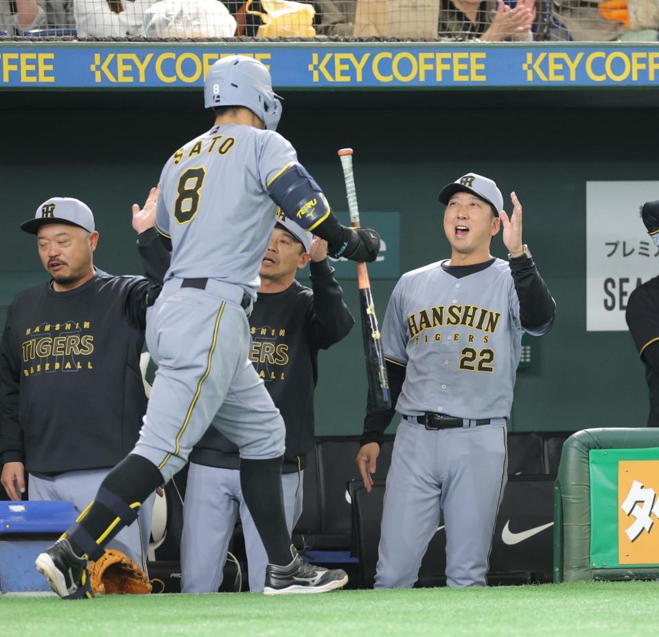 １回、先制ソロを放った佐藤輝（左）を祝福する藤川監督（撮影・西岡正）