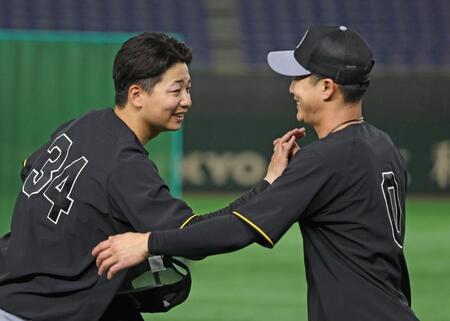 　１軍登録された漆原（左）は木浪にあいさつをする（撮影・中田匡峻）