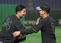 　１軍登録された漆原（左）は木浪にあいさつをする（撮影・中田匡峻）