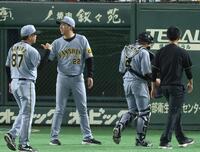 　７回、治療にベンチ裏に向かう梅野と藤川監督（撮影・金田祐二）