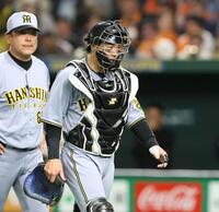 　７回、門脇のファウルチップが当たり、治療のためベンチに戻る梅野（撮影・中田匡峻）