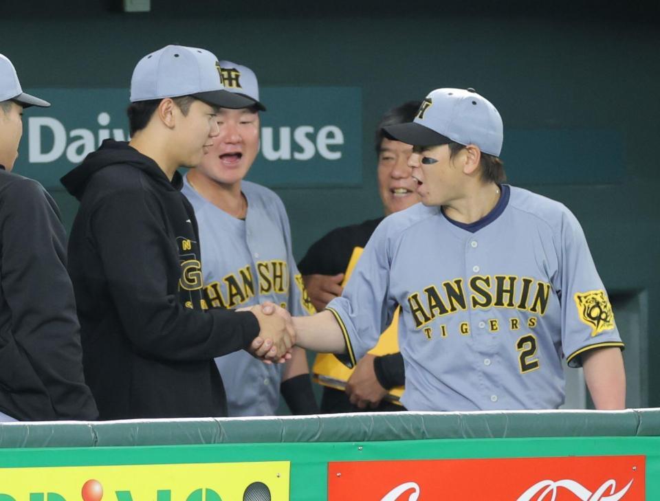 　プロ初勝利を挙げ、梅野（右）に祝福される門別（撮影・西岡正）