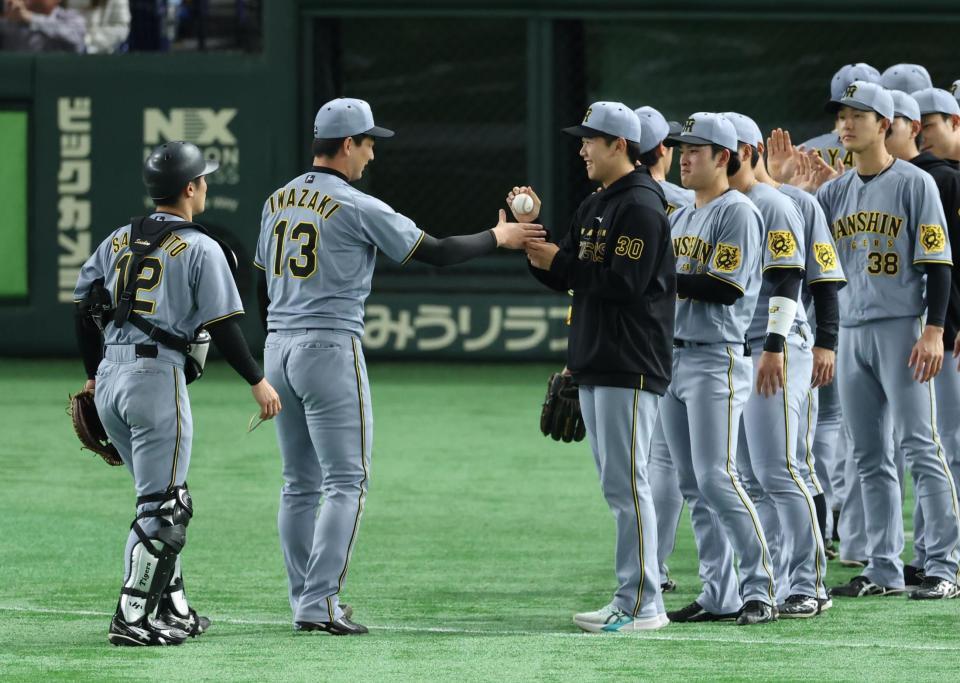 　岩崎からウイニングボールを受け取る門別（撮影・金田祐二）