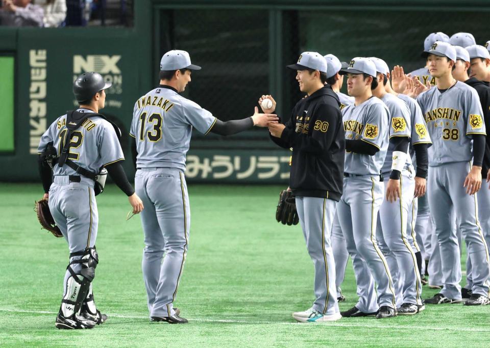 　岩崎（左）からウイニングボールを受け取る門別（撮影・金田祐二）