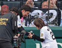 　歌唱を終えた渡瀬マキ（右）と握手を交わす藤川監督（撮影・中田匡峻）