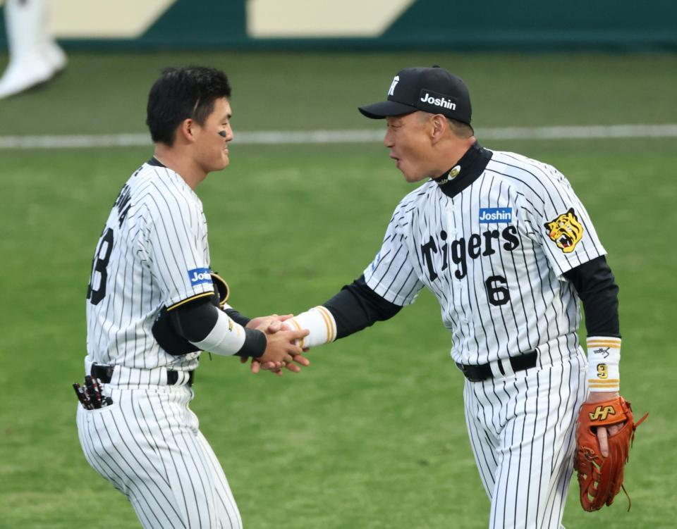 　前川（左）と握手を交わす金本知憲氏（撮影・中田匡峻）