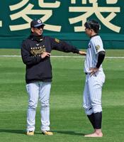 　練習の合間に藤川監督（左）に声を掛けられ話を聞く才木（撮影・立川洋一郎）