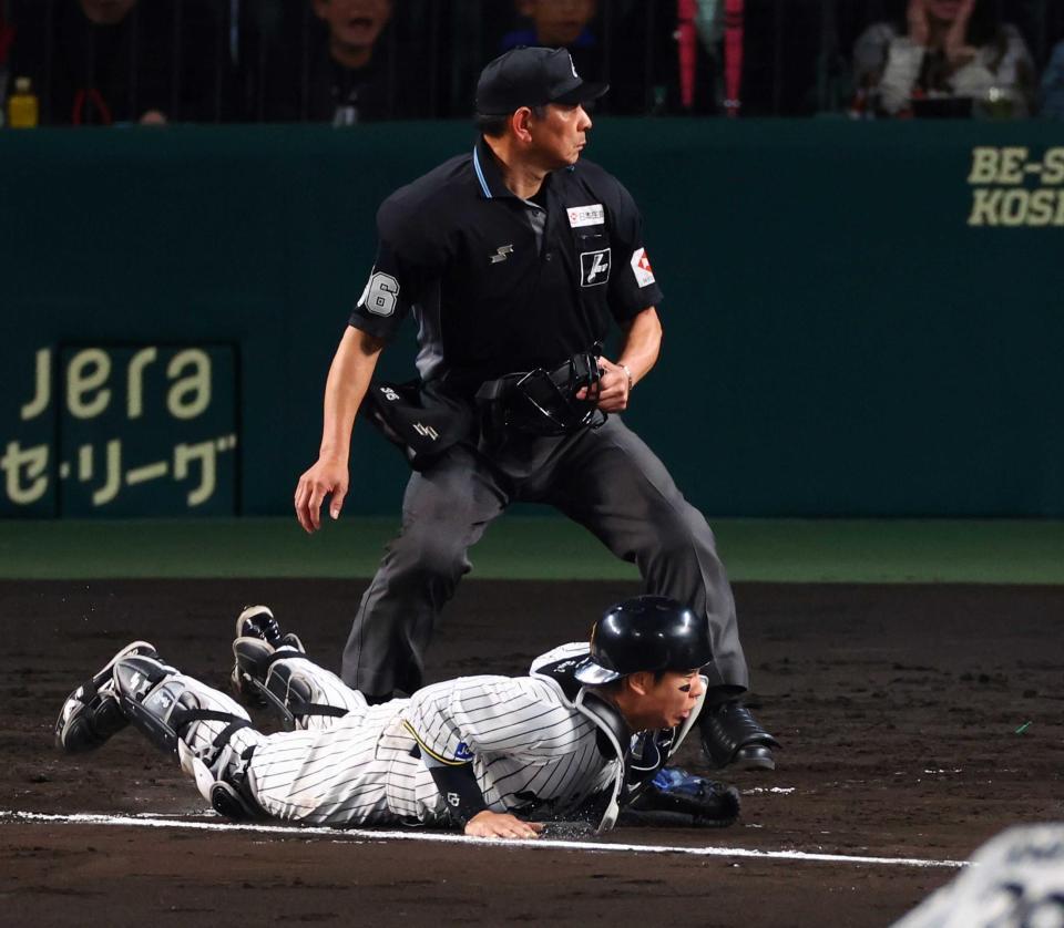 　大山からの送球がそれ、梅野が捕球できず勝ち越しを許す（撮影・山口登）