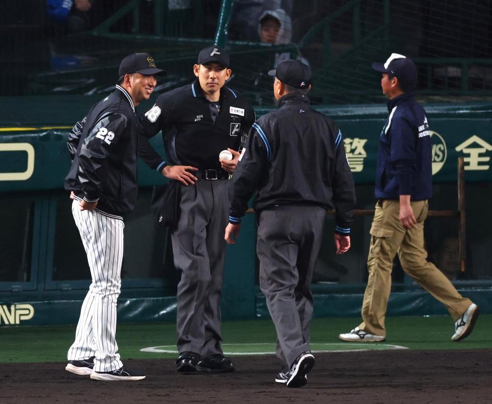 　試合再向け、藤川監督（左）は審判団と話をする（撮影・山口登）