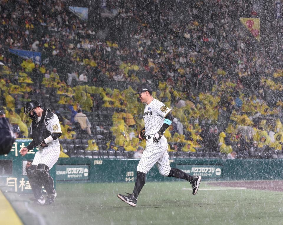 　３回途中、一端グラウンドに出たものの再び雨が降り出し、慌ててベンチに戻る佐藤輝（中央）＝撮影・北村雅宏