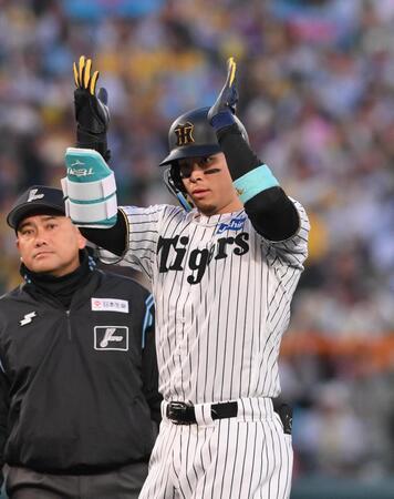 　１回、二塁打を放ち手をたたく佐藤輝（撮影・西田忠信）