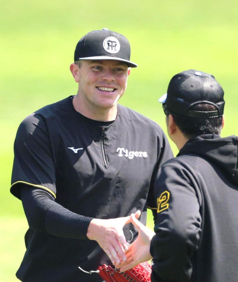 　練習中、藤川監督と握手を交わすビーズリー（左）