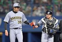 　６回、才木（左）とタッチを交わす梅野